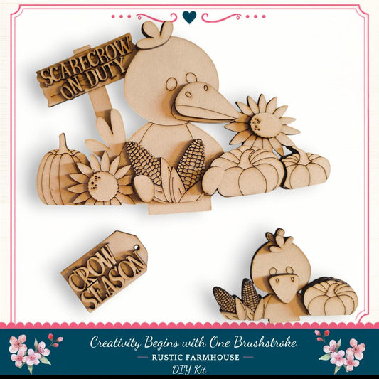 The image is a DIY kit for creating a rustic farmhouse decoration, featuring a wooden bird figure surrounded by various farm-themed items such as pumpkins, corn cobs, and a sign that says "Scarecrow on Duty".