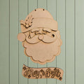 A wooden cutout of Santa Claus with a holly leaf on his hat, accompanied by a banner that says "Merry & Bright".