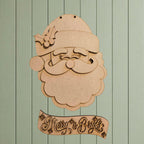 A wooden cutout of Santa Claus with a holly leaf on his hat, accompanied by a banner that says "Merry & Bright".