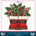 A pair of red Santa boots with white trim and gold buckles, decorated with pine cones, berries, and candy canes, arranged in a festive holiday display.