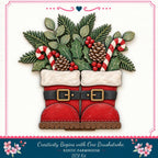 A pair of red Santa boots with white trim and gold buckles, decorated with pine cones, berries, and candy canes, arranged in a festive holiday display.