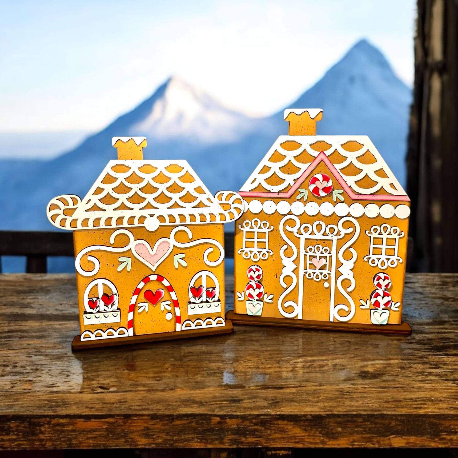 two gingerbread houses sitting on top of a wooden table