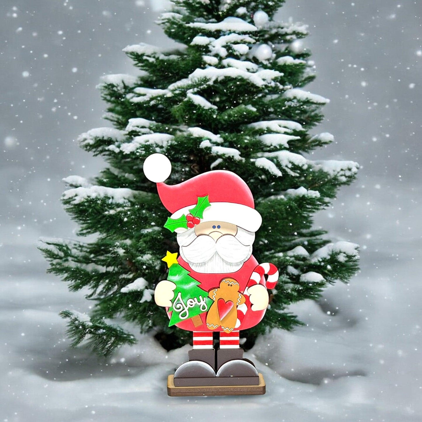 a christmas tree with a santa clause holding a teddy bear