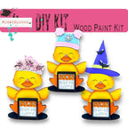 three rubber ducks wearing hats and holding a sign