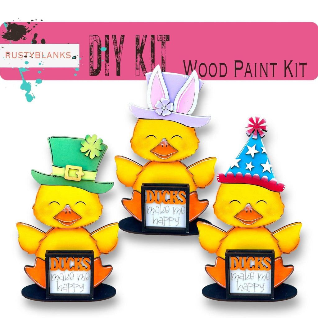 three rubber ducks wearing hats and holding a sign