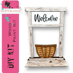 a welcome sign with a basket in front of it