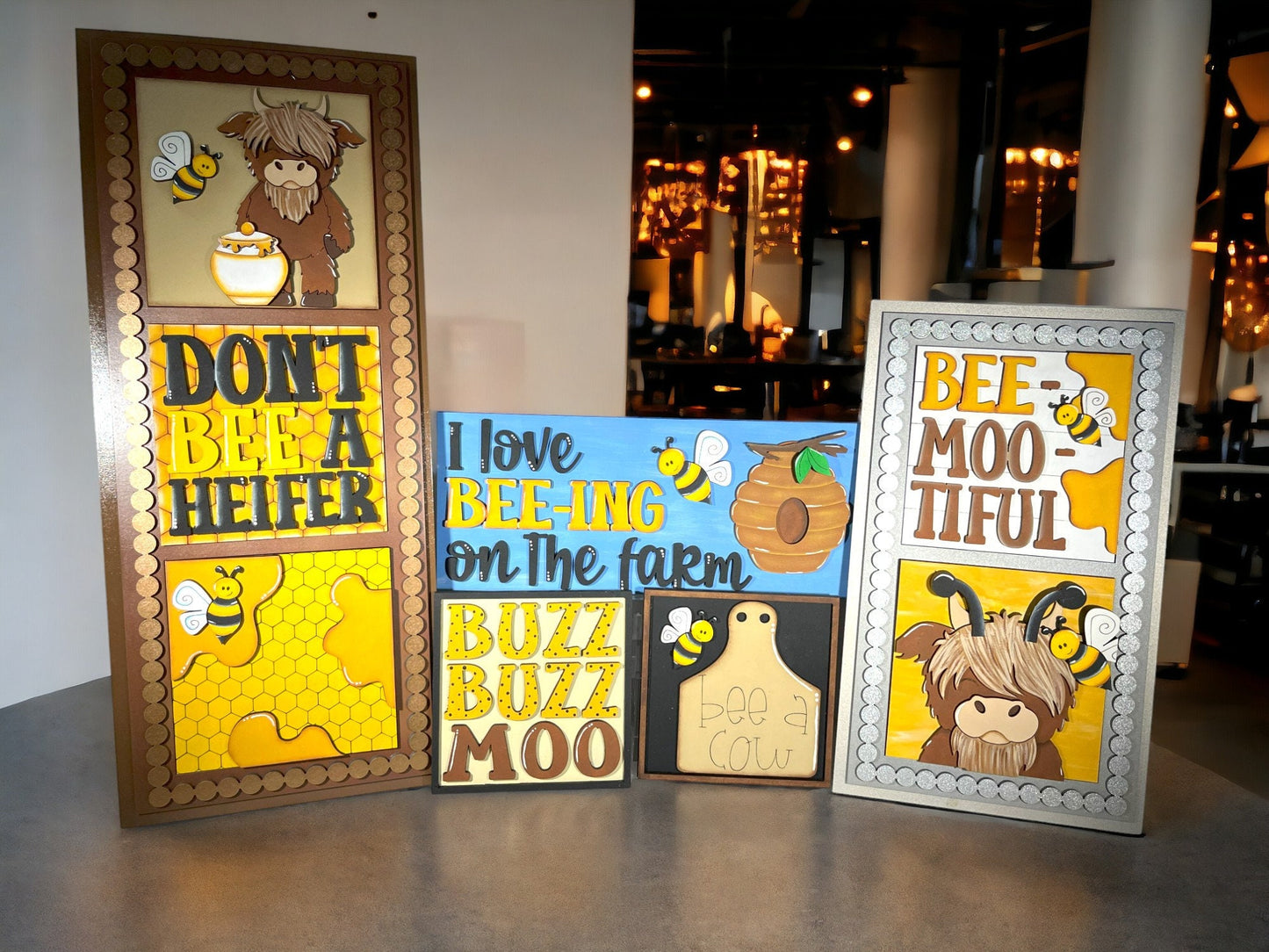 three framed pictures of animals and bees on a table