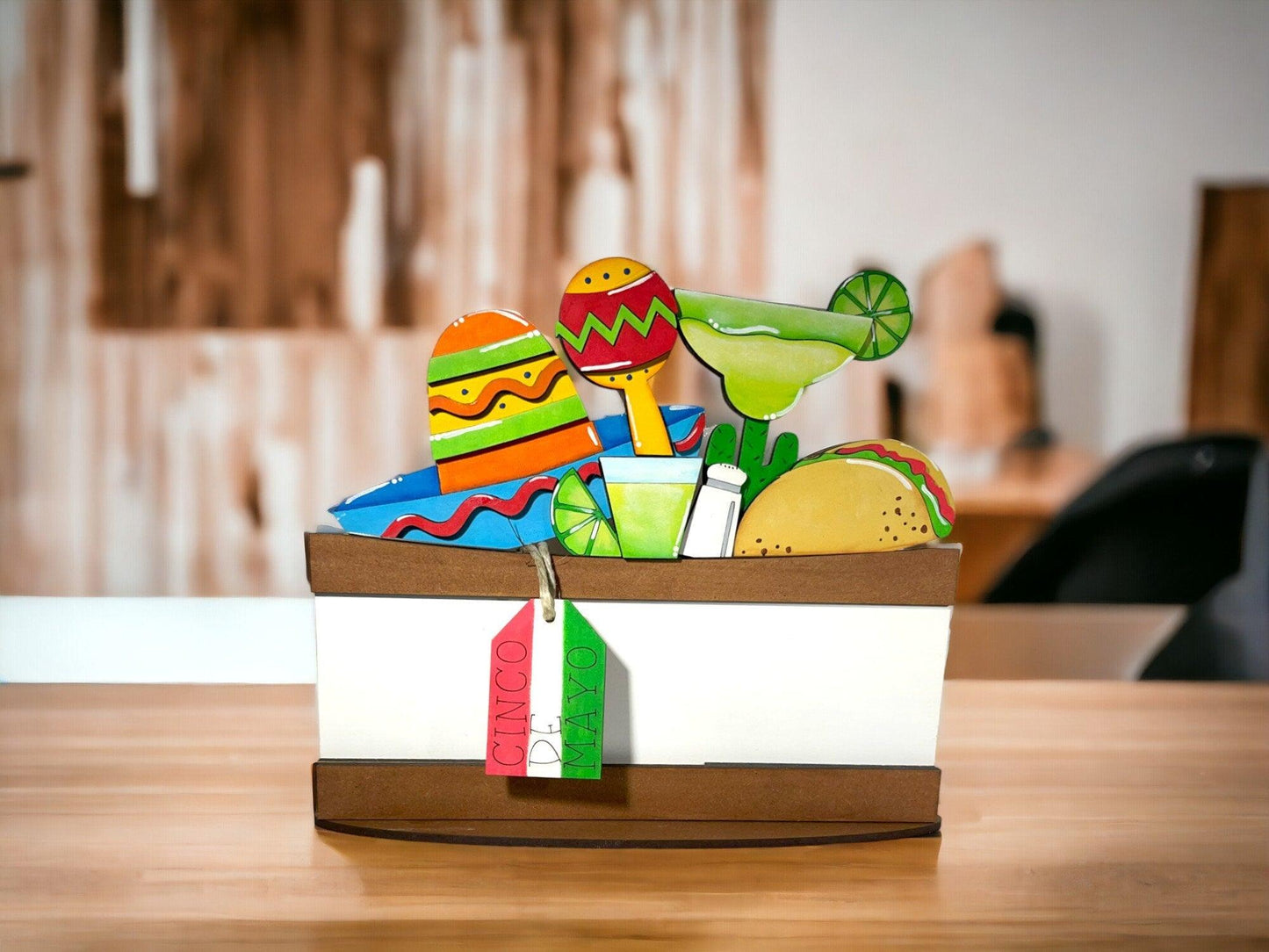 a wooden table topped with a white box filled with mexican food