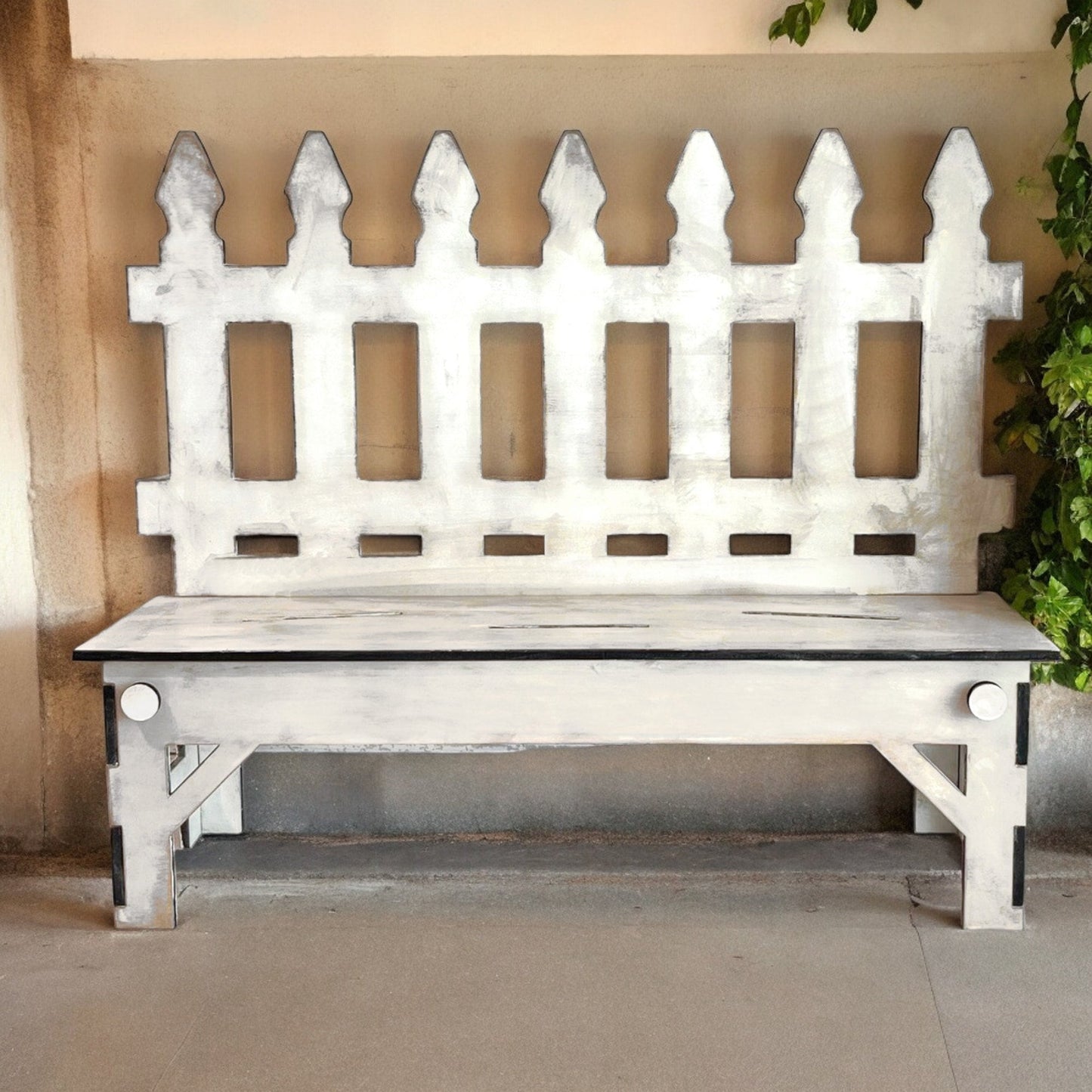 a white wooden bench sitting in front of a wall