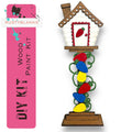 a wooden birdhouse with a red door and a pink banner
