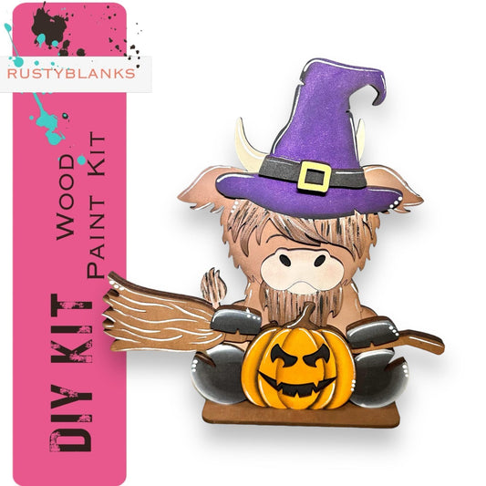 a wooden cutout of a witch holding a pumpkin