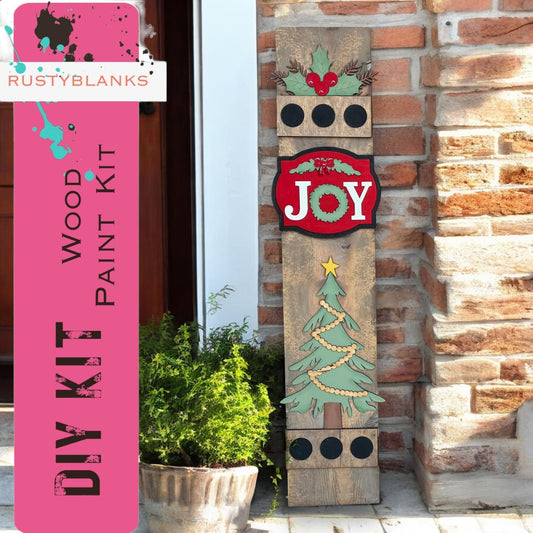 a wooden sign that says joy next to a potted plant