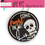 a wooden sign with a skeleton painted on it