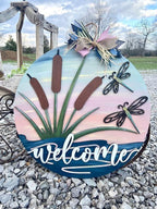 a welcome sign sitting on top of a pile of rocks