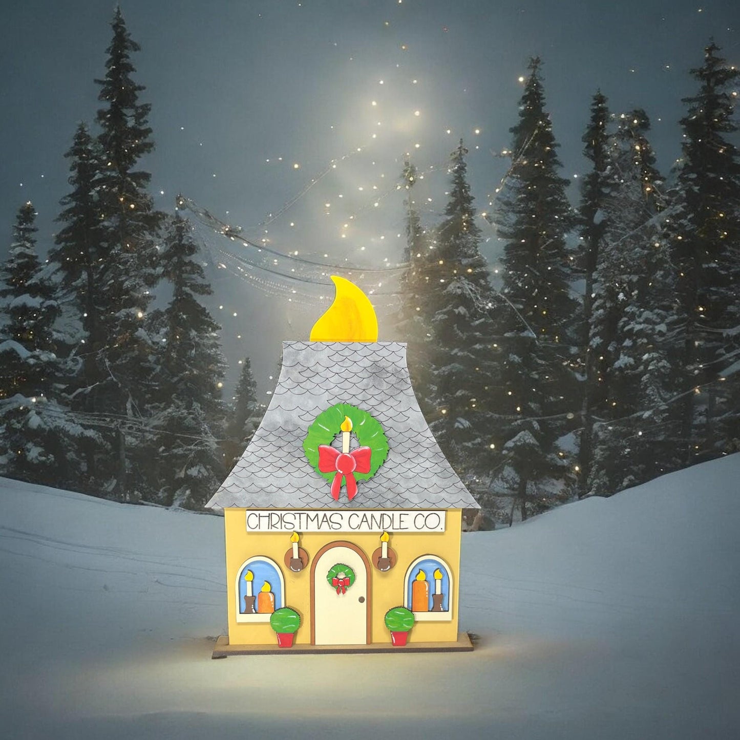 a small yellow house with a christmas wreath on top of it