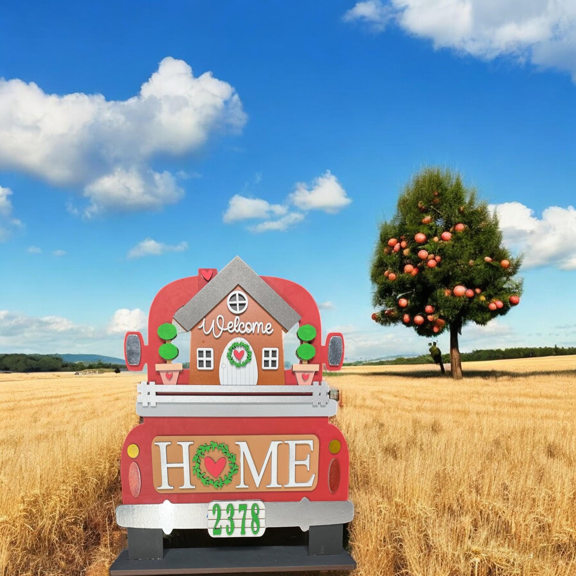 a red truck parked in a field with a tree in the background