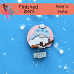 a brooch with a picture of a sheep on it