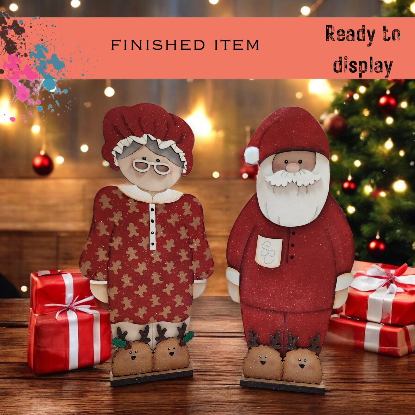 a couple of paper dolls standing next to a christmas tree