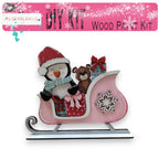 a pink snow sleigh with a penguin and a teddy bear