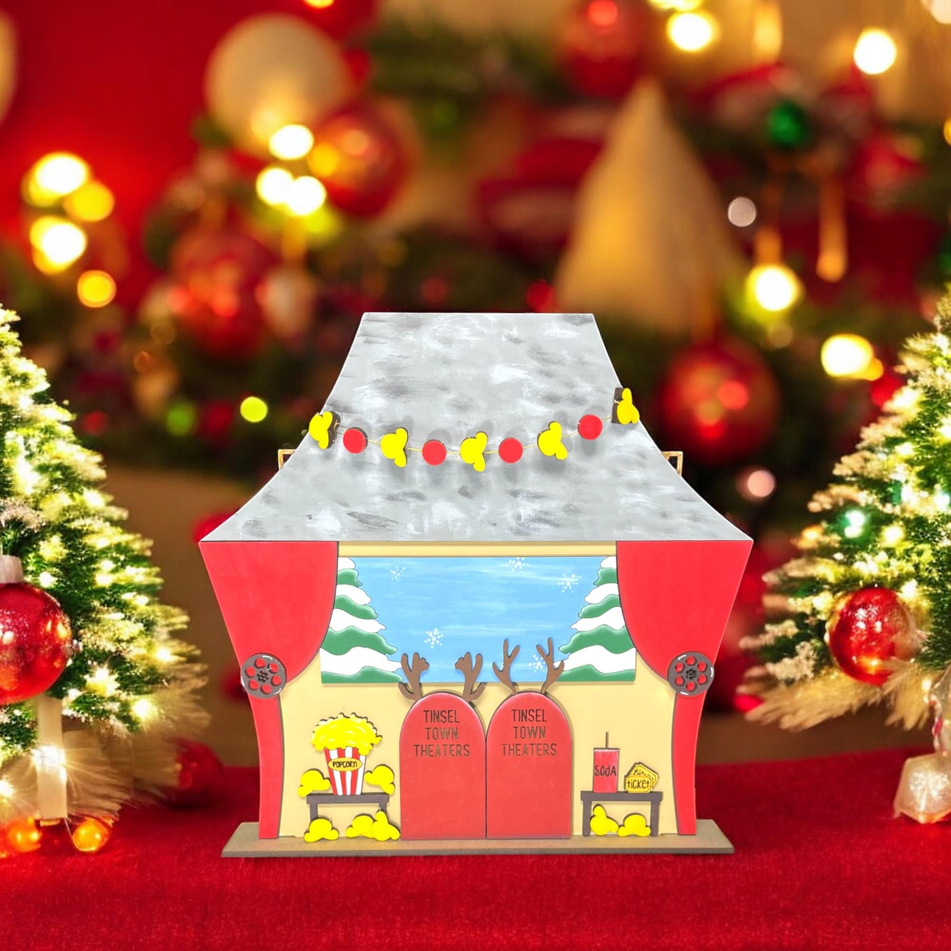 a small toy house with a christmas tree in the background